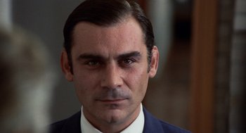 Movie still from “Investigation of a Citizen Above Suspicion” (1970), directed by Elio Petri – A person wearing a suit and tie; Close Up shot, Low angle