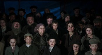 Movie still from “Invincible” (2001), directed by Werner Herzog – A large group of people are gathered together in the dark; Medium shot, High angle