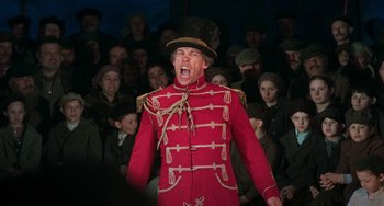 Movie still from “Invincible” (2001), directed by Werner Herzog – A man in a red jacket and a top hat; Medium shot, Low angle