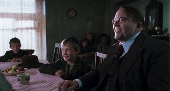 Movie still from “Invincible” (2001), directed by Werner Herzog – A man and a boy sitting at a dinner table; Medium shot, Over the shoulder angle