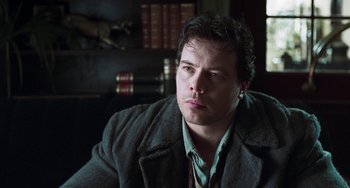 Movie still from “Invincible” (2001), directed by Werner Herzog – A person sitting in a room; Close Up shot, Low angle