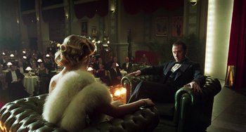 Movie still from “Invincible” (2001), directed by Werner Herzog – A man and a woman sitting in chairs in a room; Medium shot, Over the shoulder angle