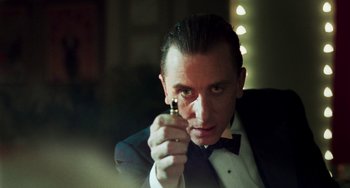Movie still from “Invincible” (2001), directed by Werner Herzog – A man in a suit and tie holding a cell phone; Close Up shot, Low angle