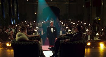 Movie still from “Invincible” (2001), directed by Werner Herzog – A man in a tuxedo standing in front of an audience; Wide shot, Over the shoulder angle