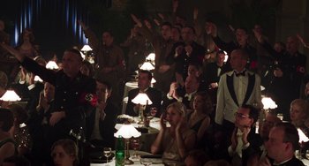 Movie still from “Invincible” (2001), directed by Werner Herzog – A group of people sitting at a table with lamps; Wide shot, High angle