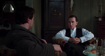 Movie still from “Invincible” (2001), directed by Werner Herzog – Two men are sitting in a chair and talking to each other; Medium shot, Over the shoulder angle