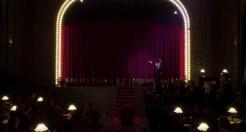 Movie still from “Invincible” (2001), directed by Werner Herzog – A man on a stage in front of an audience; Extreme Wide shot, Low angle