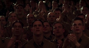 Movie still from “Invincible” (2001), directed by Werner Herzog – A group of men in military uniforms standing in front of each other; Medium shot, High angle
