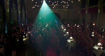 Movie still from “Invincible” (2001), directed by Werner Herzog – A group of people standing in a room with lights on; Wide shot, High angle