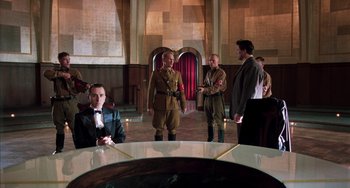 Movie still from “Invincible” (2001), directed by Werner Herzog – A group of men standing around a table in a room; Wide shot, High angle