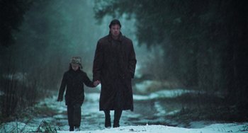 Movie still from “Invincible” (2001), directed by Werner Herzog – A man and a child walking in the snow; Wide shot, Low angle