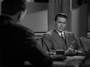 Movie still from “Invisible Agent” (1942), directed by Edwin L. Marin – A man sitting at a table in front of another man; Medium shot, Over the shoulder angle