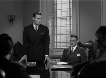 Movie still from “Invisible Agent” (1942), directed by Edwin L. Marin – Two men in suits sitting at a conference room table; Medium shot, Over the shoulder angle