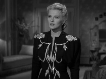 Movie still from “Invisible Agent” (1942), directed by Edwin L. Marin – An old photo of a woman in a black dress; Medium shot, Low angle