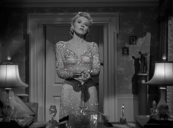 Movie still from “Invisible Agent” (1942), directed by Edwin L. Marin – A black and white photo of a woman in a dress; Medium shot, Low angle