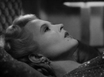 Movie still from “Invisible Agent” (1942), directed by Edwin L. Marin – Black and white photograph of a woman in a dress; Close Up shot, High angle