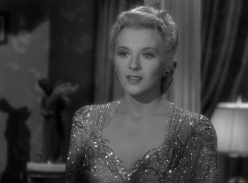 Movie still from “Invisible Agent” (1942), directed by Edwin L. Marin – A black - and - white photo of a woman with blonde hair; Close Up shot, Over the shoulder angle