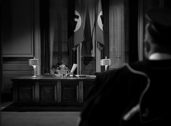Movie still from “Invisible Agent” (1942), directed by Edwin L. Marin – A black and white photo of a courtroom; Wide shot, Over the shoulder angle