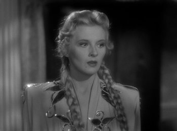 Movie still from “Invisible Agent” (1942), directed by Edwin L. Marin – A black and white photo of a woman with braids; Close Up shot, Over the shoulder angle
