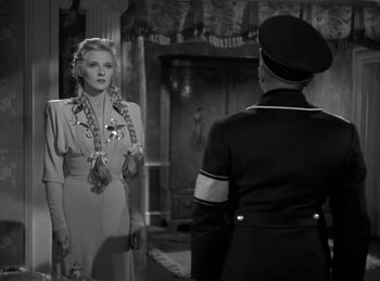 Movie still from “Invisible Agent” (1942), directed by Edwin L. Marin – A woman standing next to a man in a uniform; Medium shot, Over the shoulder angle