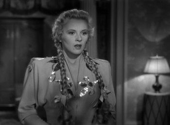 Movie still from “Invisible Agent” (1942), directed by Edwin L. Marin – A black and white photo of a woman with braids; Close Up shot, Over the shoulder angle