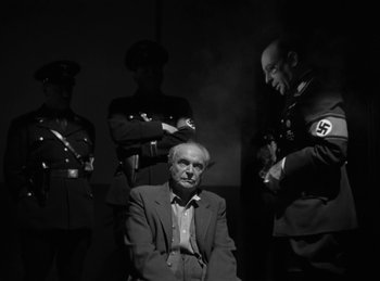 Movie still from “Invisible Agent” (1942), directed by Edwin L. Marin – An old man sitting in front of a group of soldiers; Medium shot, Low angle