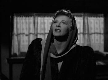 Movie still from “Invisible Agent” (1942), directed by Edwin L. Marin – A black and white photo of a woman with a scarf around her neck; Close Up shot, Low angle