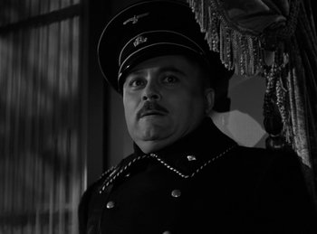 Movie still from “Invisible Agent” (1942), directed by Edwin L. Marin – A black and white photo of a man in a military uniform; Close Up shot, Low angle
