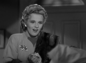 Movie still from “Invisible Agent” (1942), directed by Edwin L. Marin – A black - and - white photo of a woman in a fur coat; Close Up shot, Low angle