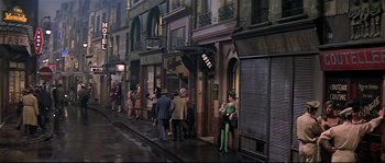 Movie still from “Irma la Douce” (1963), directed by Billy Wilder – A group of people walking down a street; Wide shot, High angle