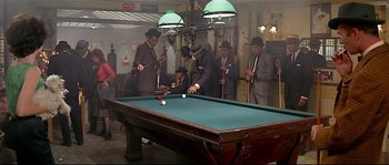 Movie still from “Irma la Douce” (1963), directed by Billy Wilder – A group of men playing a game of billiards; Wide shot, High angle
