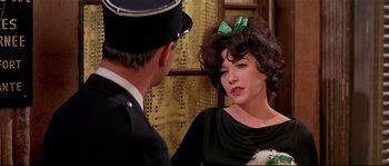 Movie still from “Irma la Douce” (1963), directed by Billy Wilder – A woman in a black dress talking to a man in a uniform; Close Up shot, Over the shoulder angle