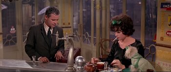 Movie still from “Irma la Douce” (1963), directed by Billy Wilder – A man and a woman sitting at a table; Medium shot, High angle