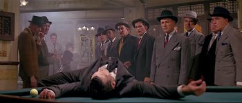 Movie still from “Irma la Douce” (1963), directed by Billy Wilder – A group of men standing around a man laying on the ground; Wide shot, Low angle