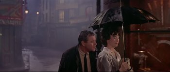 Movie still from “Irma la Douce” (1963), directed by Billy Wilder – A man and a woman under an umbrella on a rainy day; Medium shot, Low angle