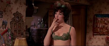 Movie still from “Irma la Douce” (1963), directed by Billy Wilder – A woman smoking a cigarette while wearing a bra; Close Up shot, Low angle