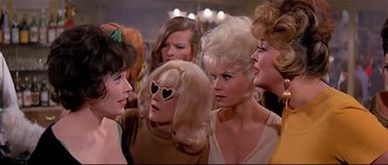 Movie still from “Irma la Douce” (1963), directed by Billy Wilder – A group of women standing next to each other in a room; Medium shot, Low angle