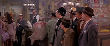 Movie still from “Irma la Douce” (1963), directed by Billy Wilder – A group of men standing in a room; Wide shot, Over the shoulder angle