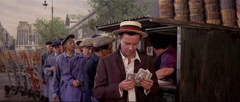 Movie still from “Irma la Douce” (1963), directed by Billy Wilder – A man wearing a hat and holding a bunch of money; Medium shot, Low angle