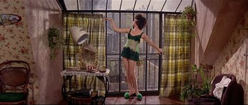 Movie still from “Irma la Douce” (1963), directed by Billy Wilder – A woman in a green dress standing in front of a window; Wide shot, High angle