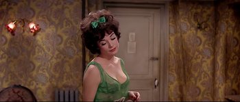 Movie still from “Irma la Douce” (1963), directed by Billy Wilder – A woman in a green dress is standing in front of a door; Close Up shot, Over the shoulder angle