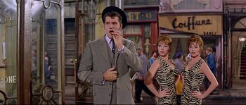 Movie still from “Irma la Douce” (1963), directed by Billy Wilder – A man and woman standing next to each other in front of a building; Medium shot, Low angle