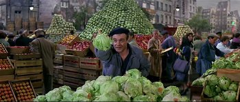 Movie still from “Irma la Douce” (1963), directed by Billy Wilder – A man holding a lettuce in front of a pile of lettuce; Medium shot, High angle