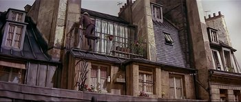 Movie still from “Irma la Douce” (1963), directed by Billy Wilder – A man is standing on the balcony of a building; Wide shot, Low angle