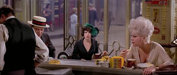 Movie still from “Irma la Douce” (1963), directed by Billy Wilder – A woman sitting at a table in front of a mirror; Medium shot, Over the shoulder angle