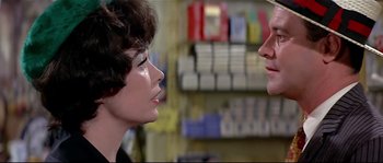 Movie still from “Irma la Douce” (1963), directed by Billy Wilder – A woman in a store talking to a man in a store; Close Up shot, Over the shoulder angle