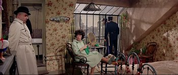 Movie still from “Irma la Douce” (1963), directed by Billy Wilder – A woman sitting on a chair in a room; Wide shot, High angle