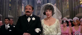 Movie still from “Irma la Douce” (1963), directed by Billy Wilder – A man and a woman standing next to each other in front of a clock tower; Medium shot, Over the shoulder angle