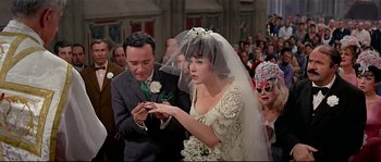 Movie still from “Irma la Douce” (1963), directed by Billy Wilder – A woman in a wedding dress and veil holding a wedding ring; Close Up shot, Over the shoulder angle
