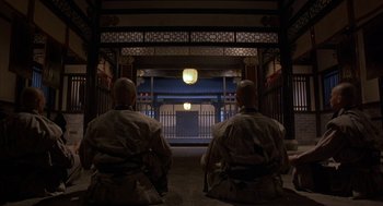 Movie still from “Iron Monkey” (1993), directed by Woo-Ping Yuen – Two men sitting in front of a building at night; Wide shot, Low angle